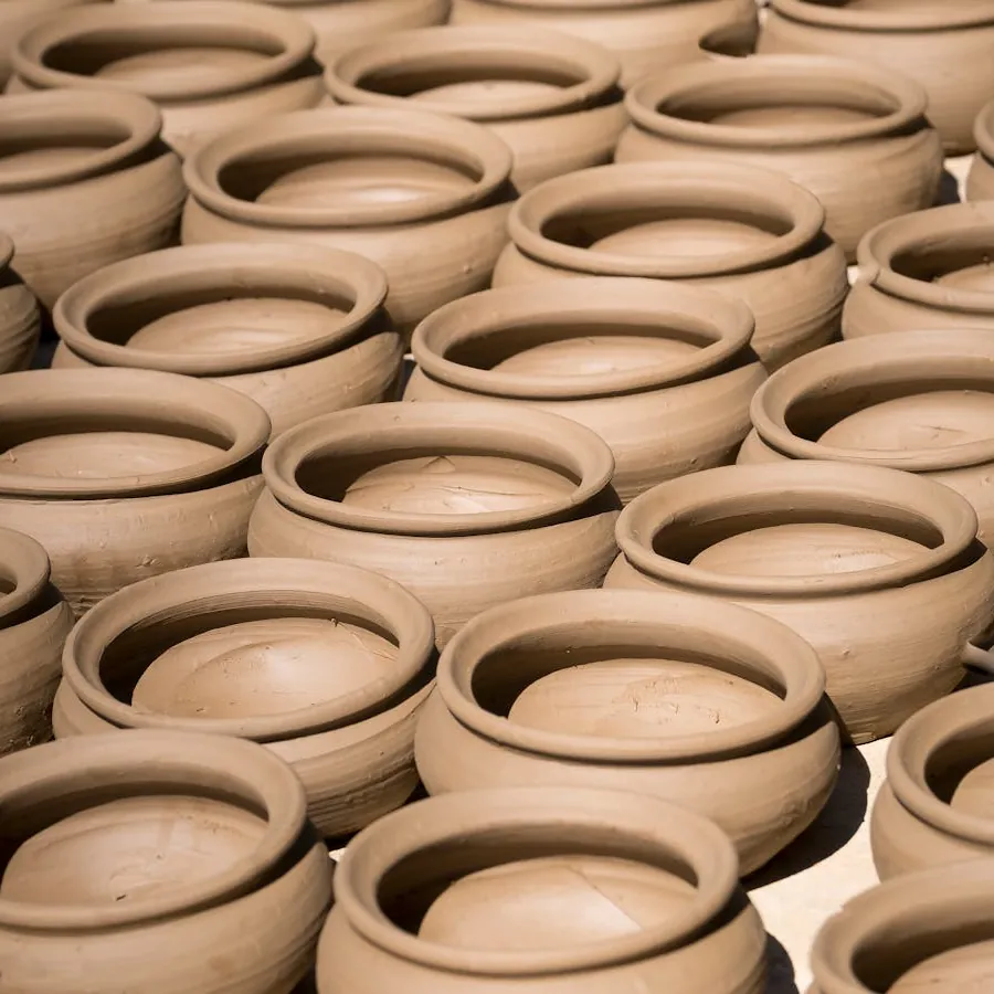 A potter's hands shaping wet clay on the wheel