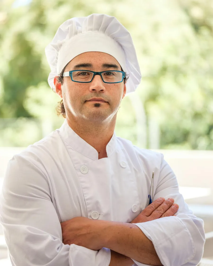 Chef Élodie Renard in the kitchen, lit by warm candlelight