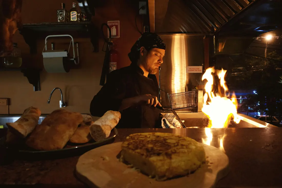 Chef Élodie Renard cooking over open flame at night