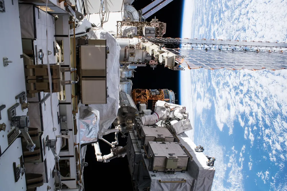 An APSIS crew member on a spacewalk, the curve of the Earth filling the visor.