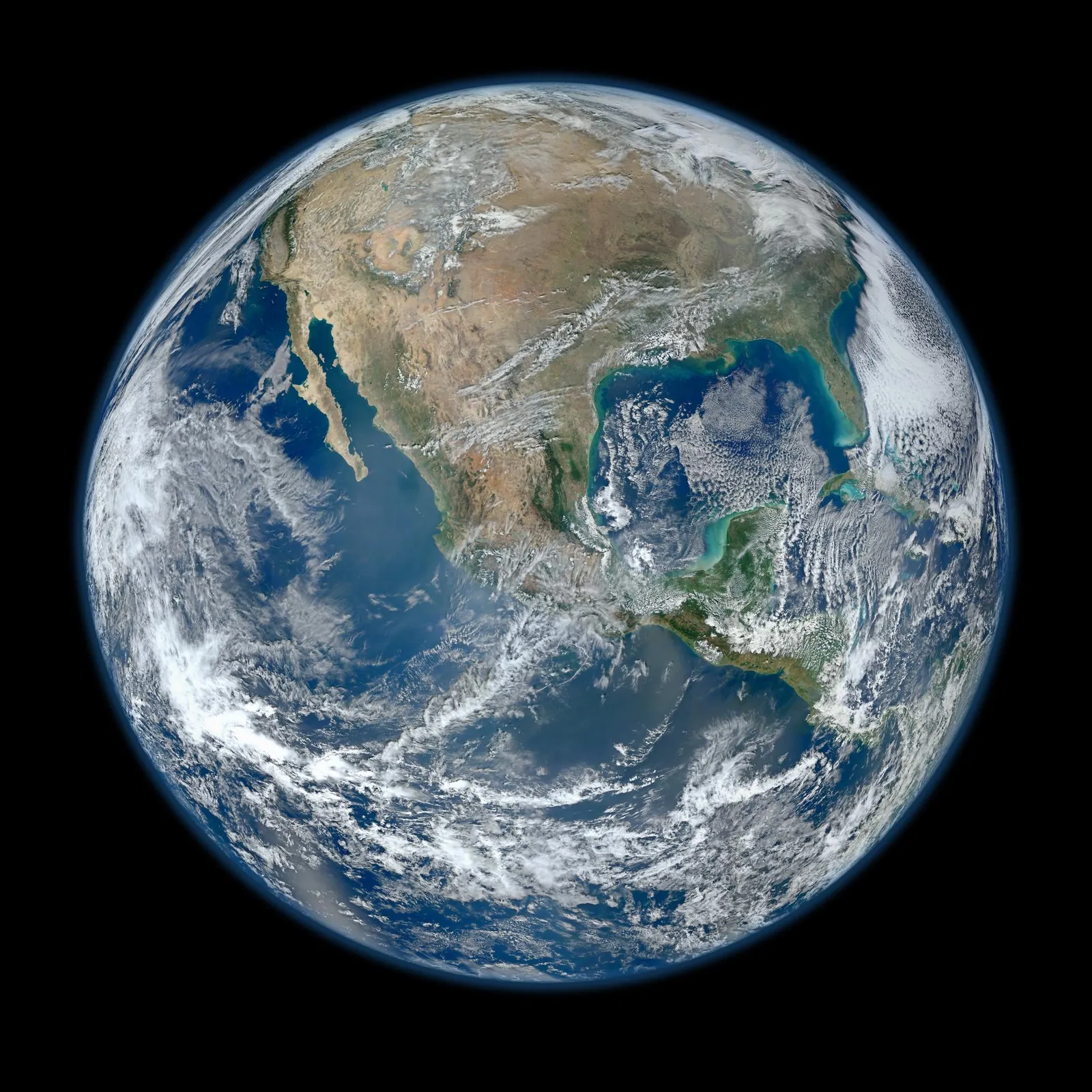 Earth seen from low orbit, the thin blue line of the atmosphere against deep space.