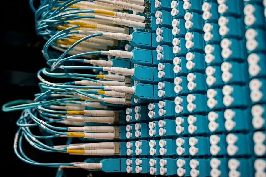 OKTET technician inspecting a switch mainboard under inspection lamps